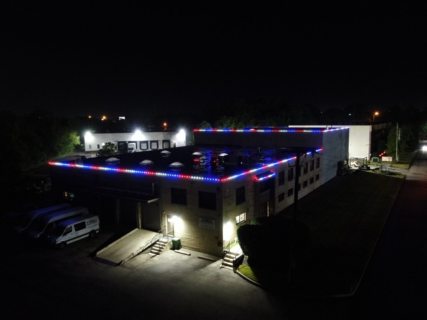 Commercial building with its roofline outlined in red, white, and blue lights at night